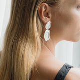 Elegant EIRA duo earrings in recycled gold and silver, showcasing sustainable handmade craftsmanship, worn by a model.