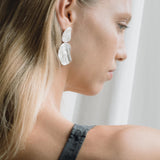 Model showcasing EIRA duo earrings, handcrafted from recycled silver and gold, emphasizing sustainable and ethical jewelry.