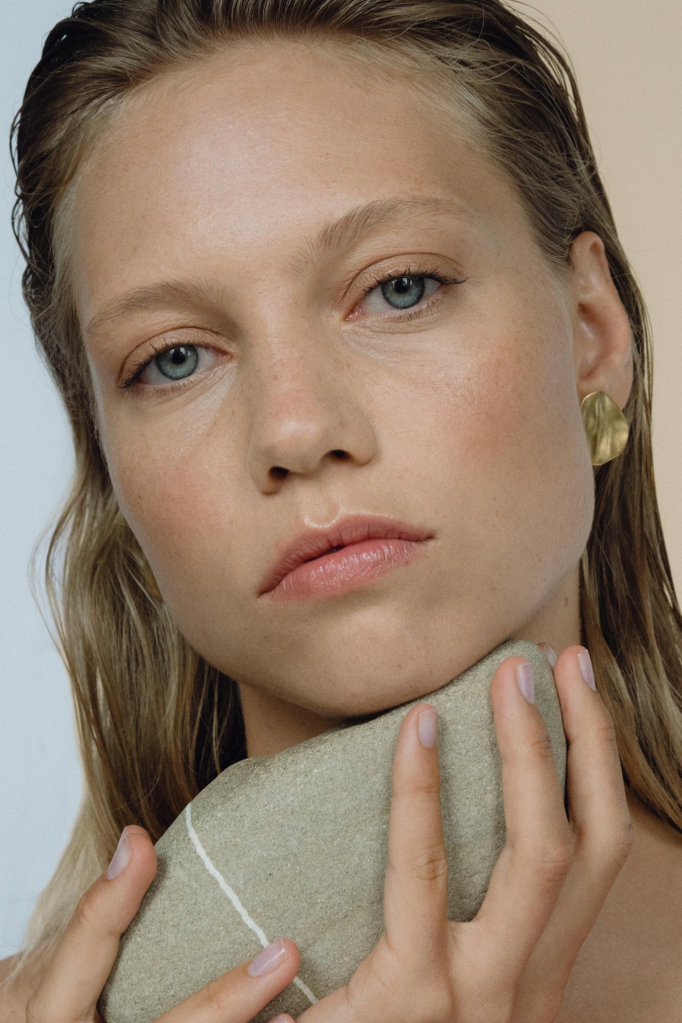 Model showcasing EIRA solo earrings, emphasizing sustainable, ethical jewelry made of recycled gold and silver.