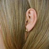 Side view of a model wearing ELV handmade earrings, crafted from recycled gold with a matte finish, promoting ethical jewelry.