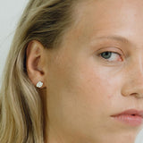 Close-up of a model wearing ELV earrings, showcasing ethical handmade jewelry in recycled gold and silver.