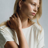 Model wearing LUMI big earrings, showcasing handmade, sustainable ethical jewelry with a natural shiny finish.