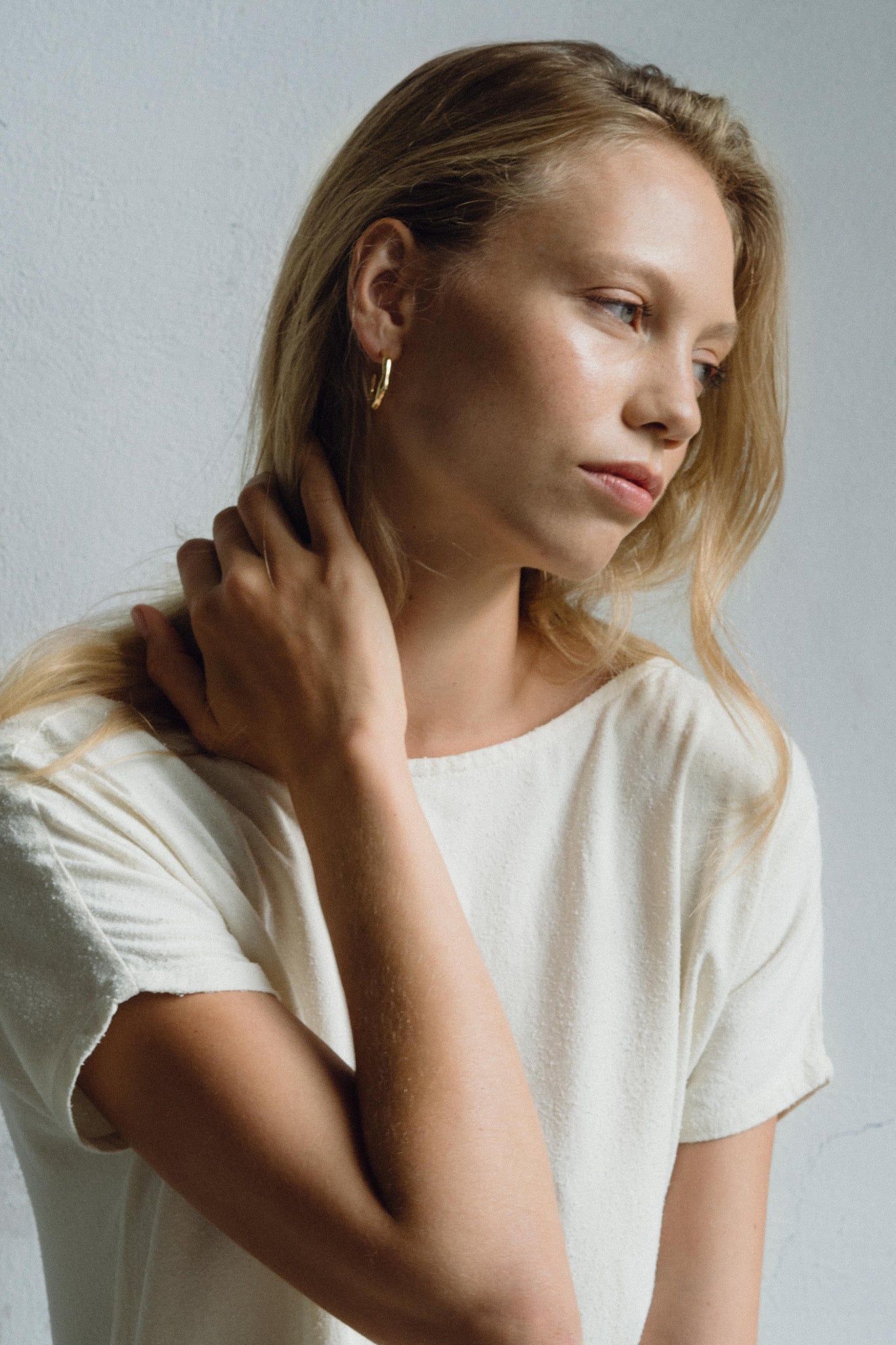 Model wearing LUMI big earrings, showcasing handmade, sustainable ethical jewelry with a natural shiny finish.