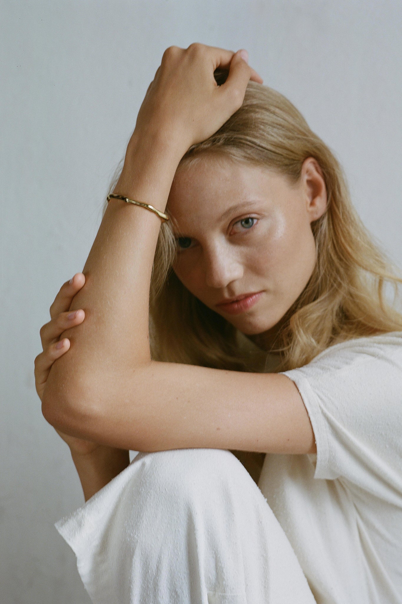 Model wearing LUMI cuff, an adjustable ethical jewelry piece made of recycled gold and silver.