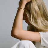 Woman wearing the LUMI cuff bracelet, showcasing ethical handmade jewelry made from recycled gold and silver.