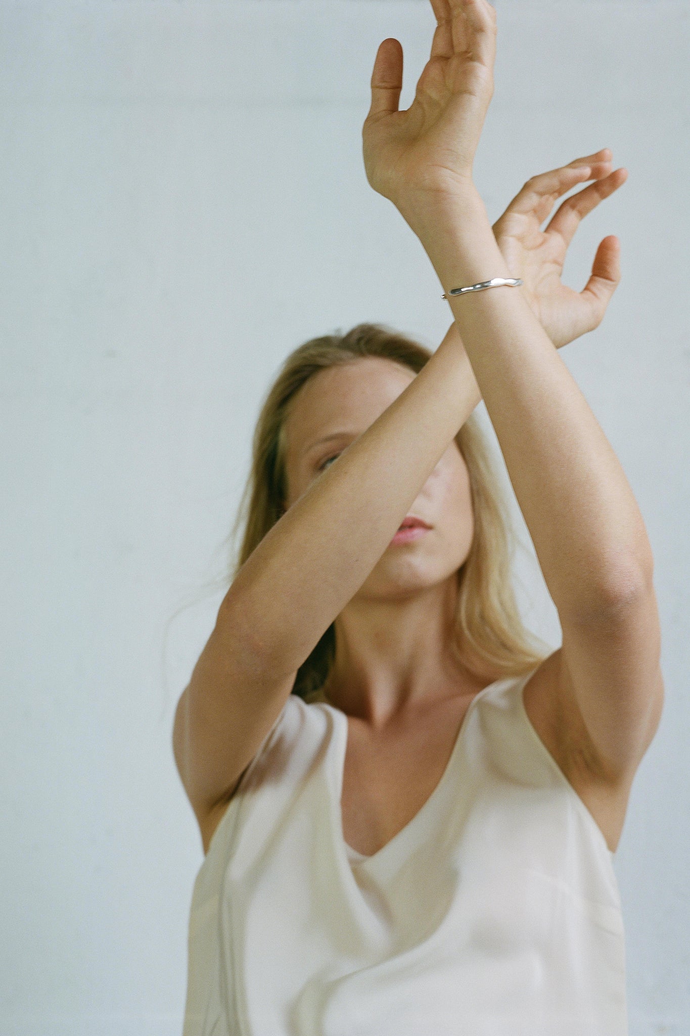 Model showcasing the LUMI cuff, an adjustable ethical jewelry piece made from recycled gold and silver.