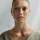 Model showcasing MOA earrings, made from recycled gold and silver, emphasizing ethical jewelry and sustainable craftsmanship.