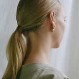 Model showcasing MOA earrings made of recycled gold, highlighting ethical jewelry and sustainable fashion.