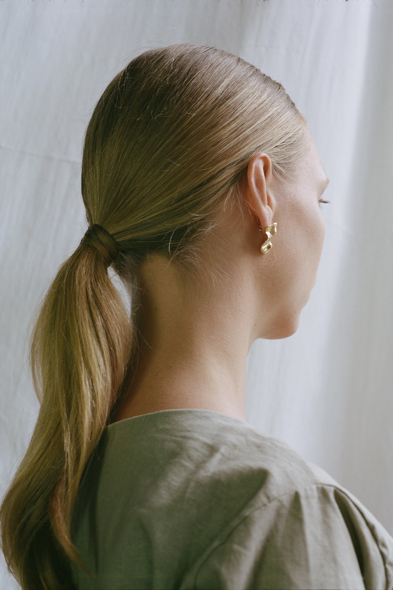 Model showcasing MOA earrings made of recycled gold, highlighting ethical jewelry and sustainable fashion.