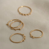 Handcrafted 18k recycled gold rings set on soft fabric, showcasing organic designs from Basel Switzerland.