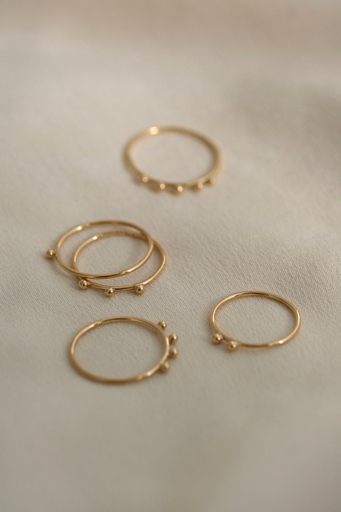 Handcrafted 18k recycled gold rings set on soft fabric, showcasing organic designs from Basel Switzerland.