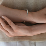 Sustainable handmade DROP 04 bracelet in 925 recycled silver, featuring a satin finish, styled on a model's wrist.