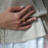 Hand holding a gold-plated ring, showcasing ethical and sustainable jewelry made in Basel, Switzerland.