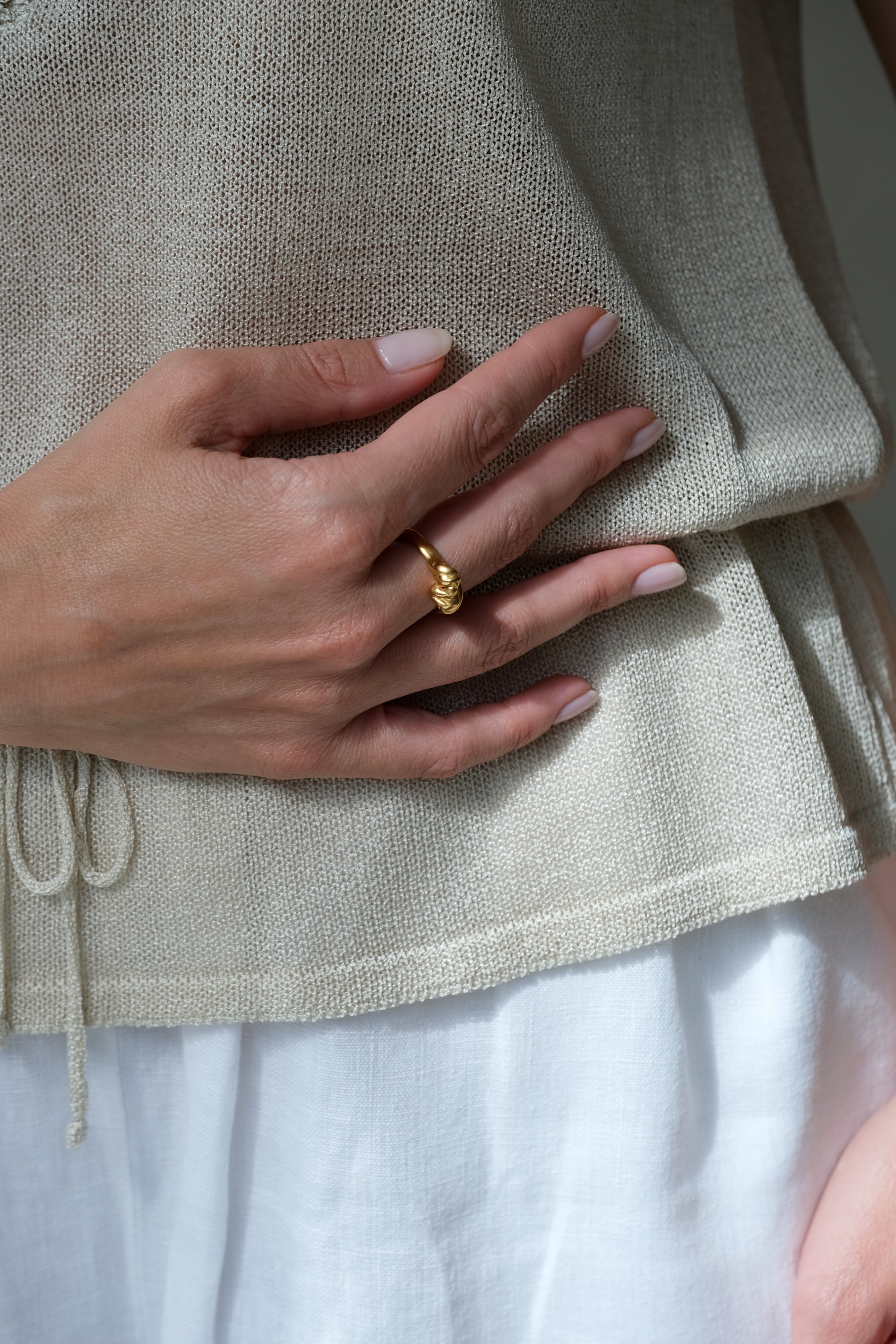Hand holding a gold-plated ring, showcasing ethical and sustainable jewelry made in Basel, Switzerland.