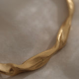 Close-up of a unique handmade gold-plated bracelet featuring an organic wave design, crafted in Basel, Switzerland.