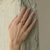 Hand wearing DROP 01 ring made of 18k gold-plated recycled silver, showcasing unique ethical jewelry.