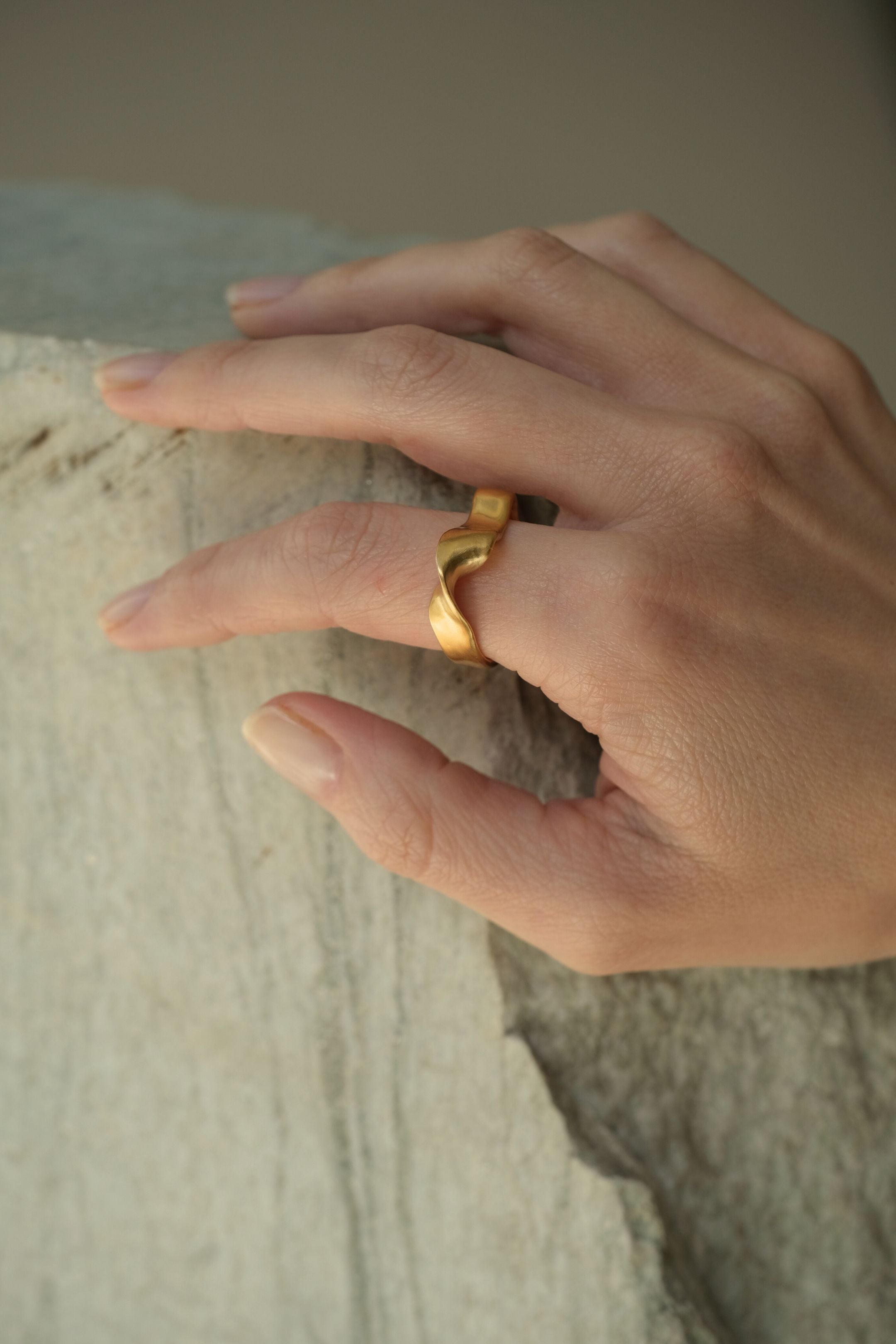 Hand wearing DROP 01 ring two, featuring sustainable 18k gold-plated recycled silver, handmade in Basel.