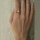 Hand wearing the DROP 01 ring, a unique handmade piece in 18k gold-plated recycled silver, designed in Basel, Switzerland.