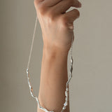 Hand holding DROP 02 necklace, handmade in Basel, featuring 925 recycled silver and unique design.