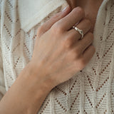 Hand wearing DROP 02 ring, showcasing unique handmade design in 925 recycled silver, styled with a knit top.
