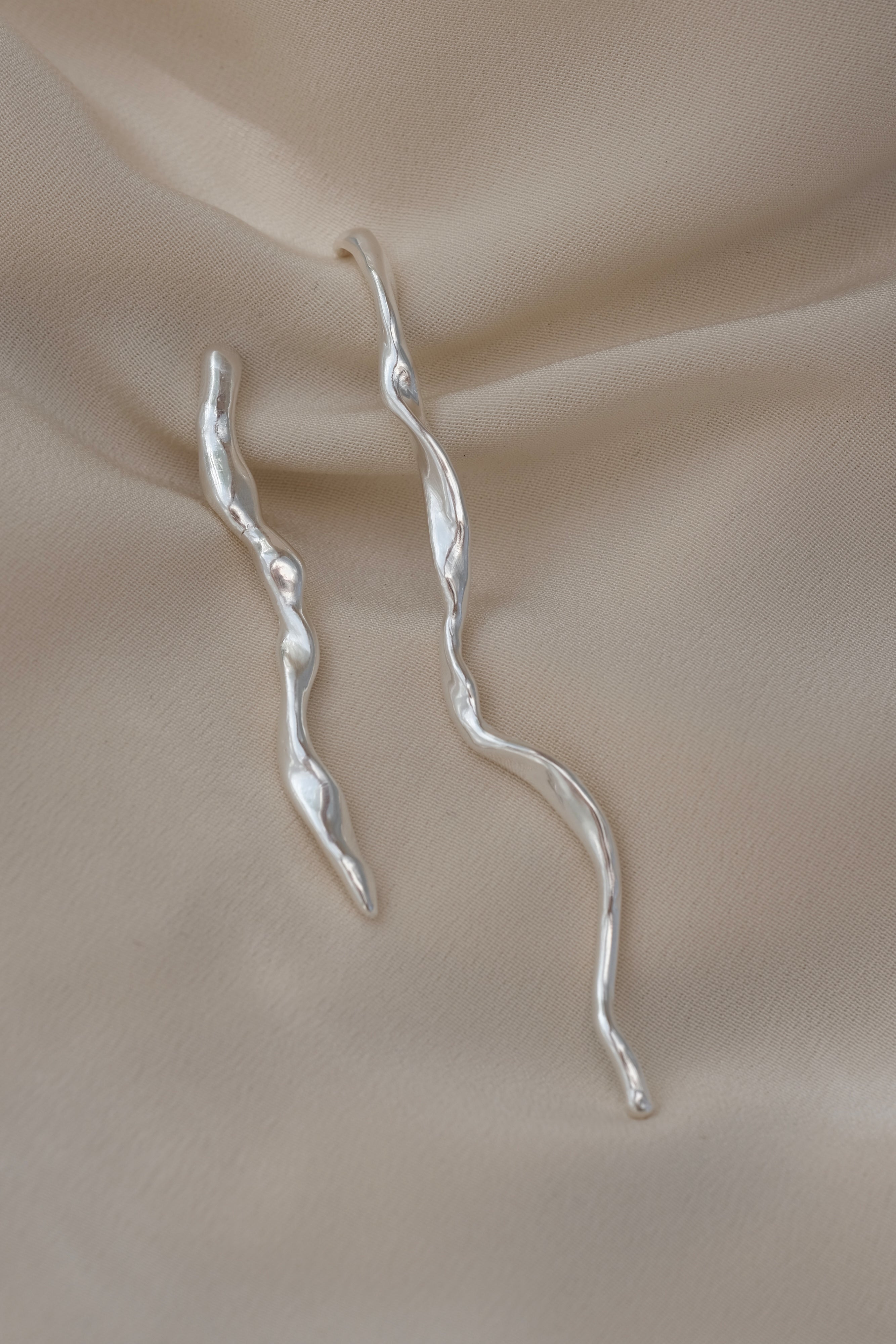 DROP 02 earrings handmade in Basel, Switzerland from sustainable 925 recycled silver, featuring unique twisted designs.