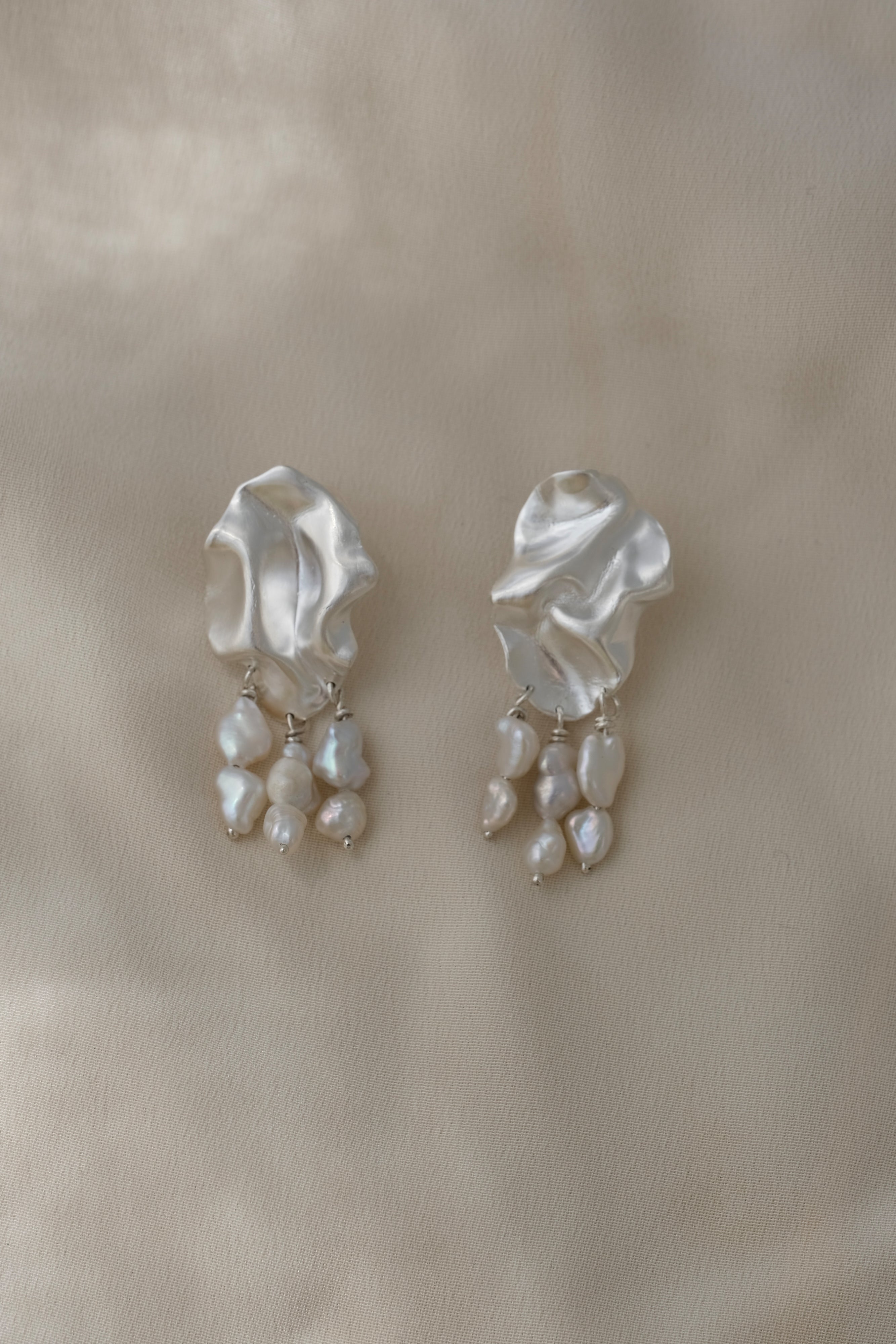Handmade unique earrings with textured design and hanging pearls, crafted from sustainable materials in Basel, Switzerland.