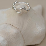 Handmade unique ring crafted from 925 recycled silver, resting on a shell, symbolizing ethical and sustainable jewelry.