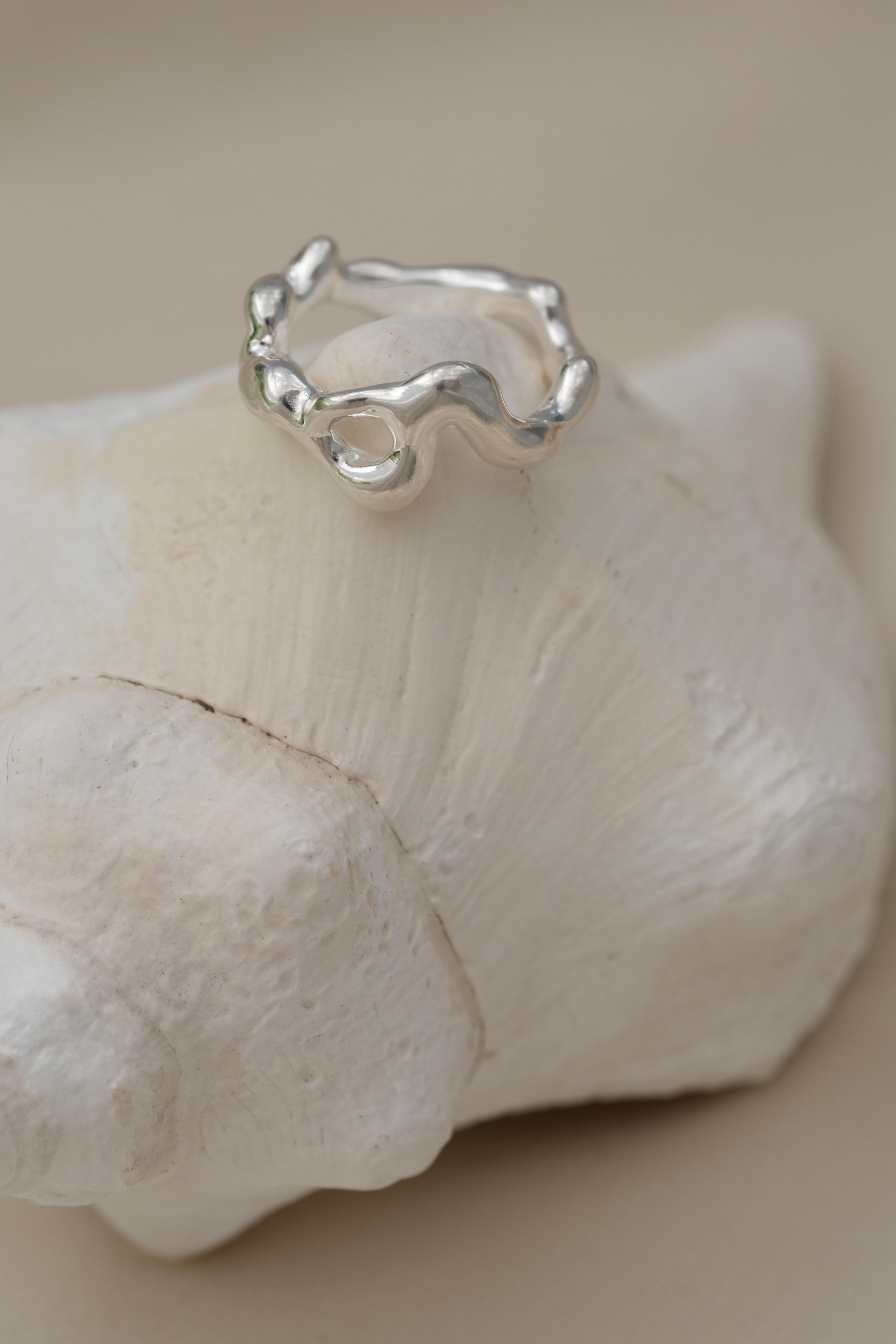 Handmade unique ring crafted from 925 recycled silver, resting on a shell, symbolizing ethical and sustainable jewelry.