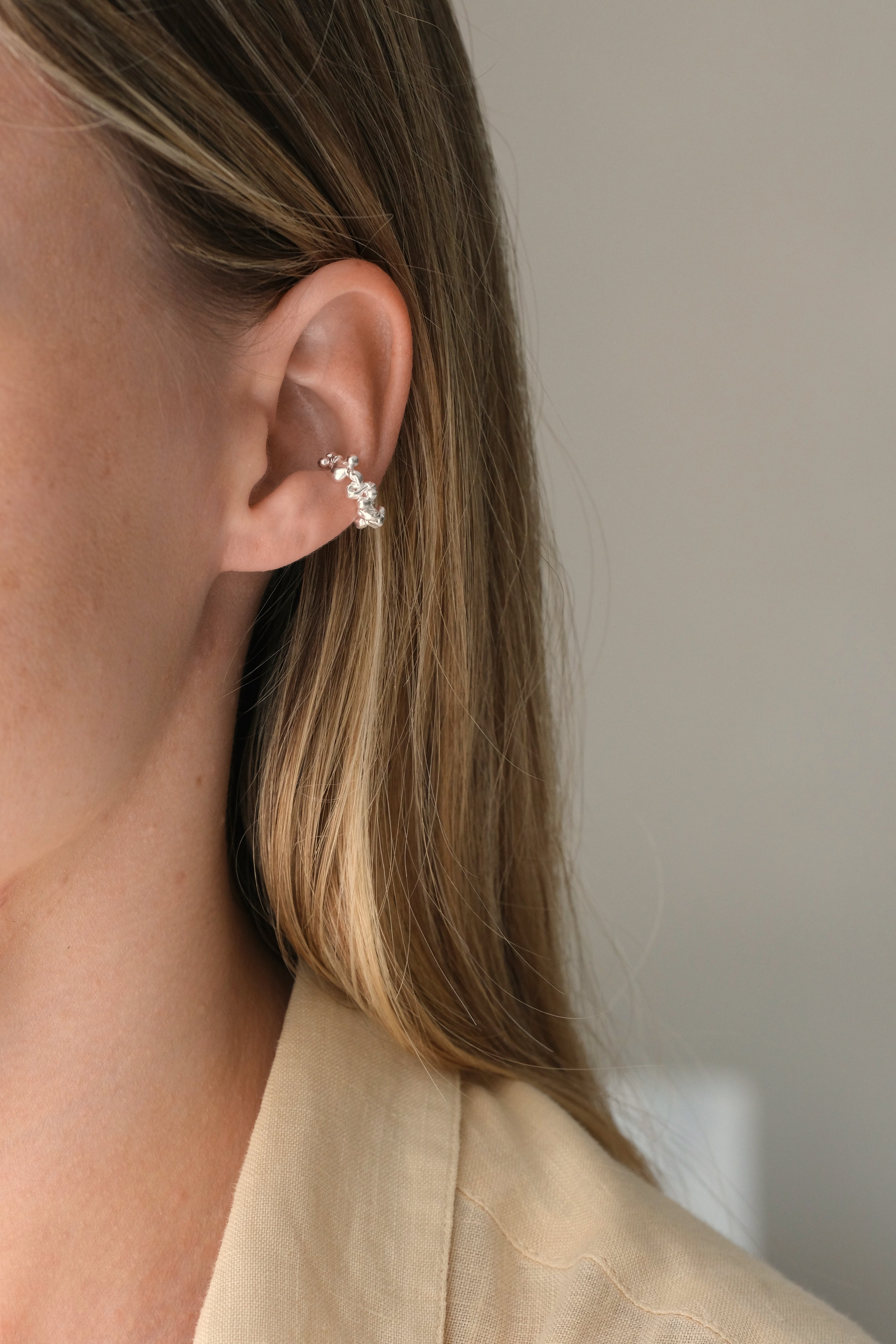 Close-up of a woman wearing a handmade ear cuff in 925 recycled silver, showcasing ethical jewelry design in Basel, Switzerland.