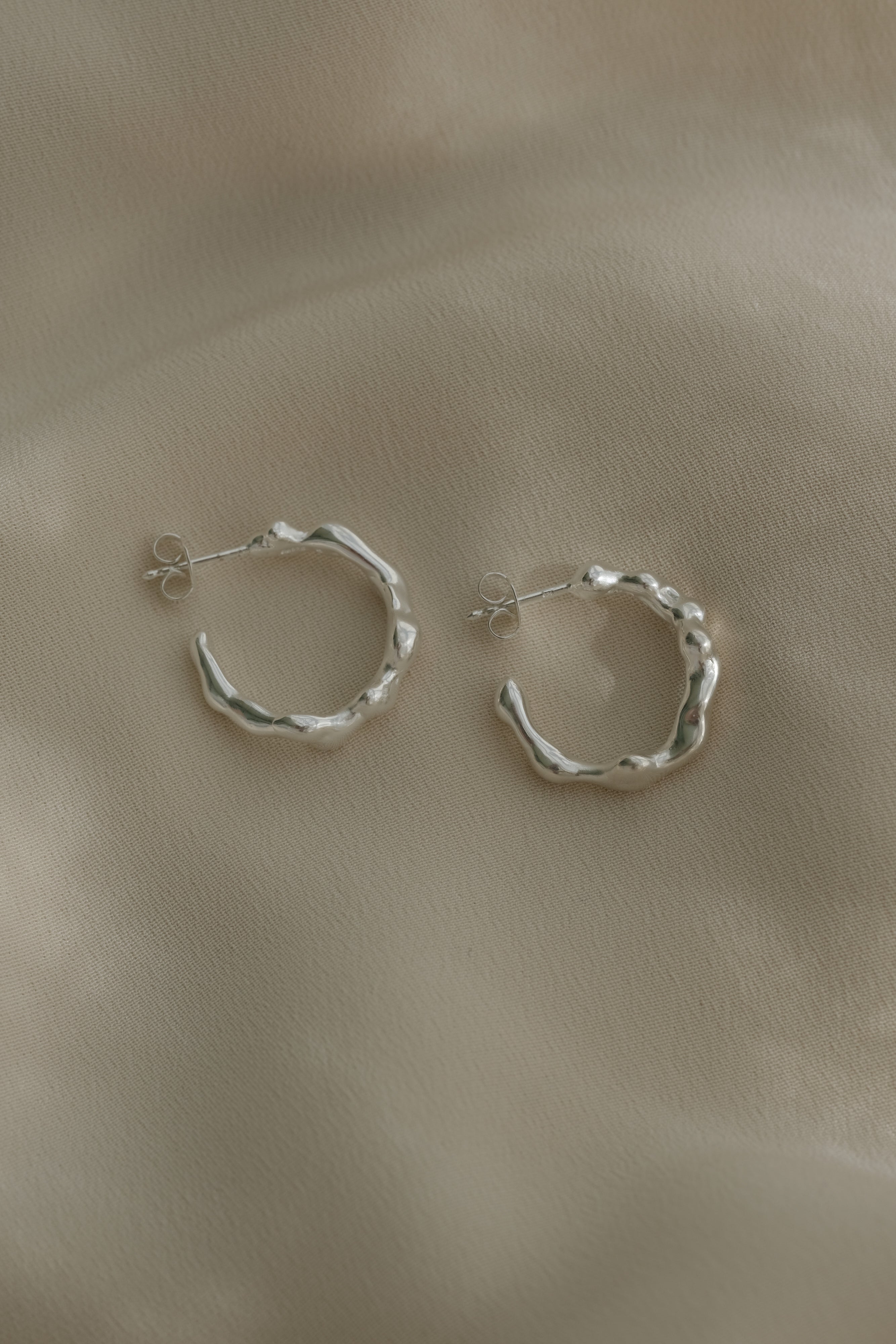 Handmade silver hoop earrings, ethical and sustainable jewelry, crafted in Basel, Switzerland, showcasing unique design.