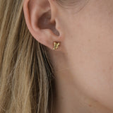 Handmade ethical earrings in recycled yellow gold, showcasing a unique design, worn by a model in Basel, Switzerland.