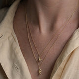 Two layered necklaces in recycled gold showcased on a model, embodying ethical and sustainable jewelry from Basel, Switzerland.