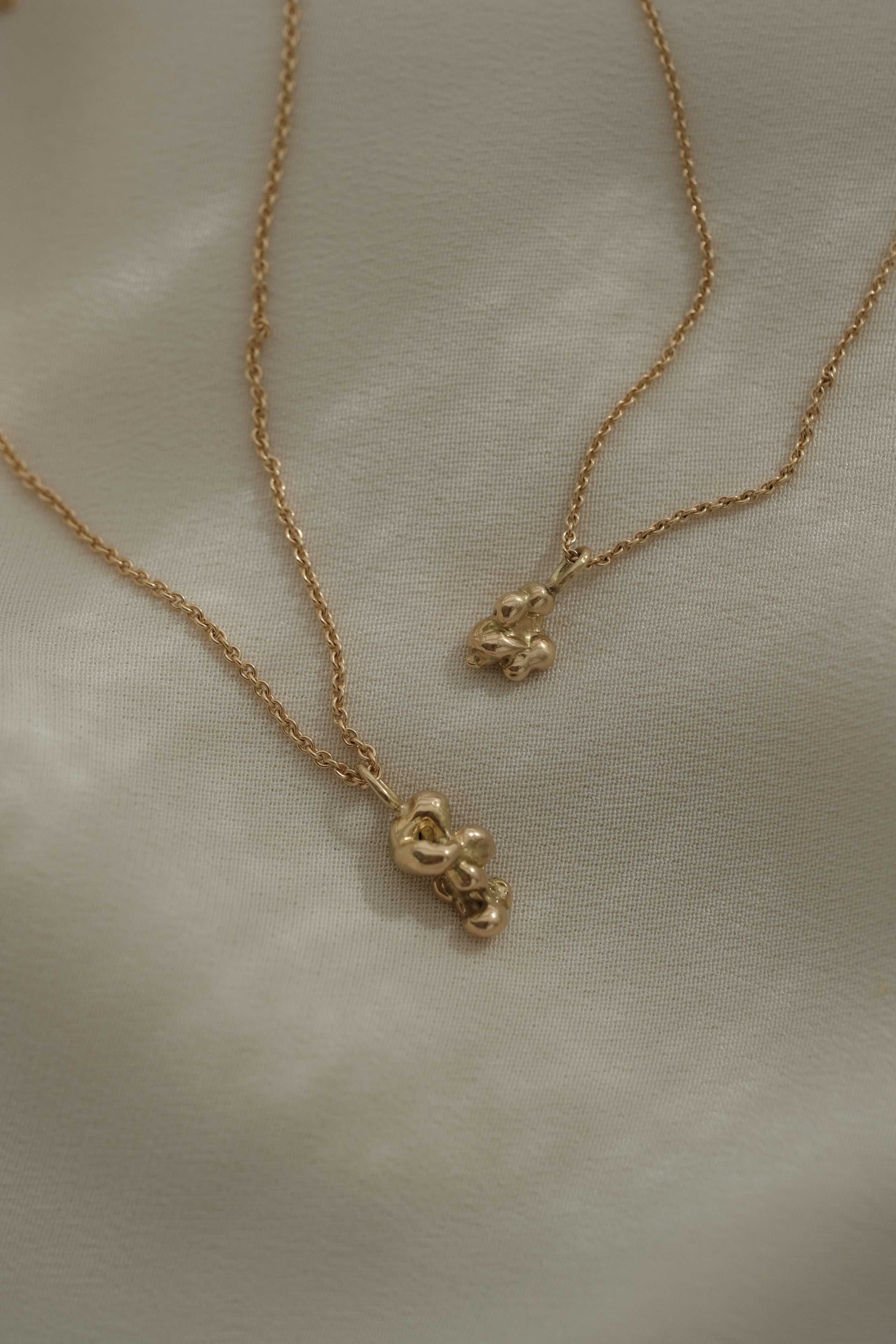 Handmade ethical and sustainable jewelry, featuring two unique necklaces in recycled 18k yellow gold from Basel, Switzerland.