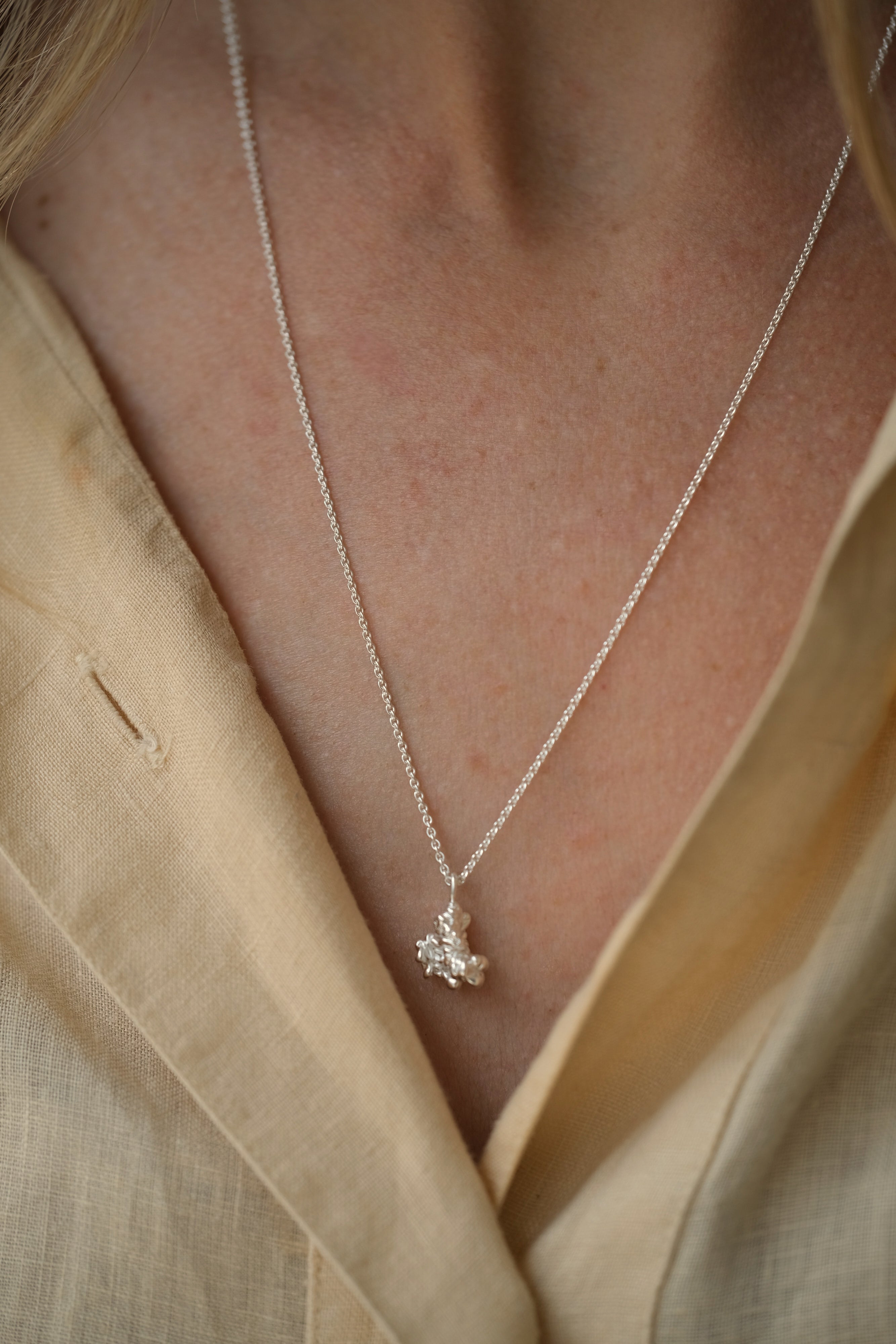 Handmade DROP 03 necklace in 925 recycled silver, showcasing unique design and satin finish, worn on a model.