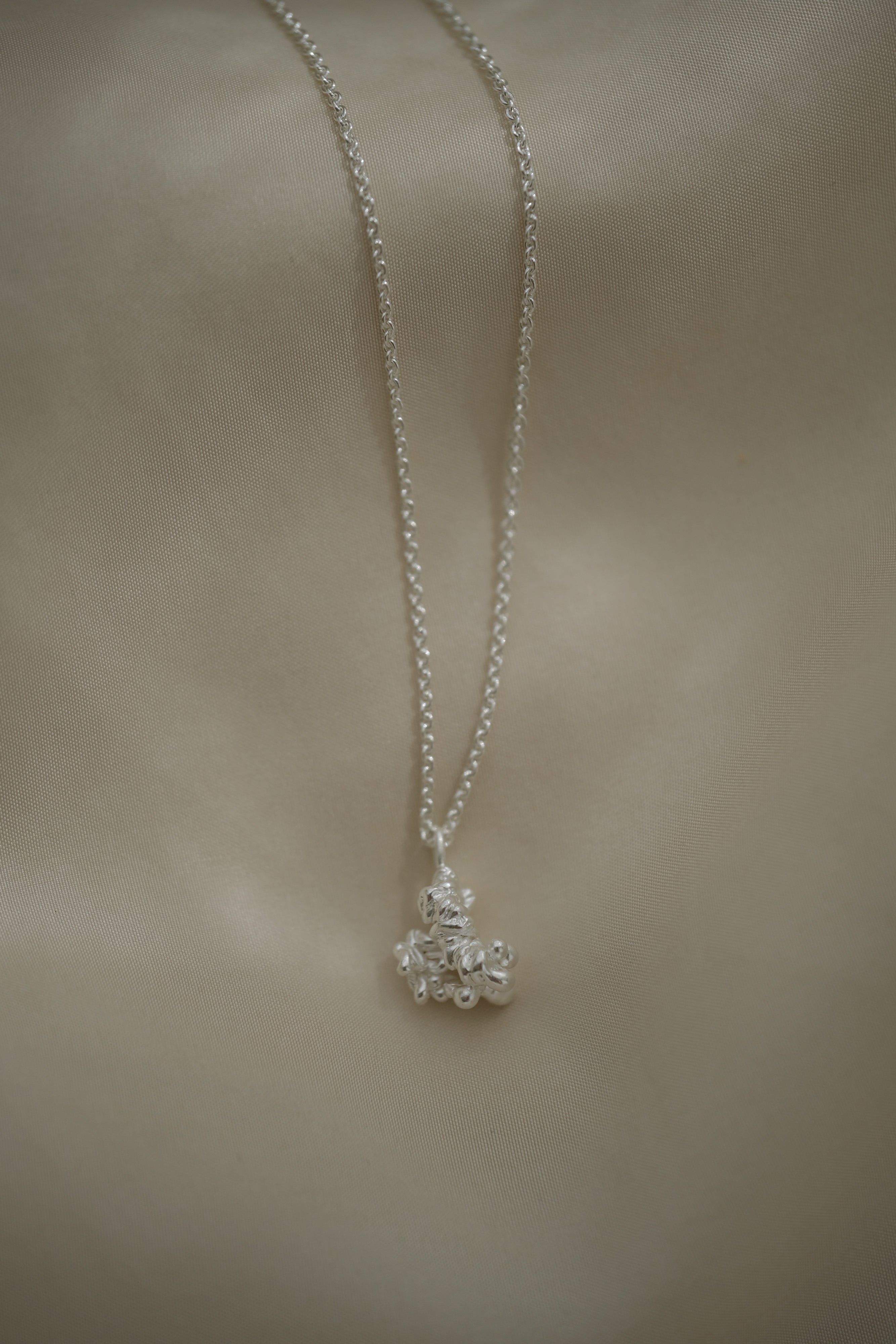 DROP 03 necklace in recycled silver, handmade in Basel, showcasing unique ethical jewelry with satin finish.