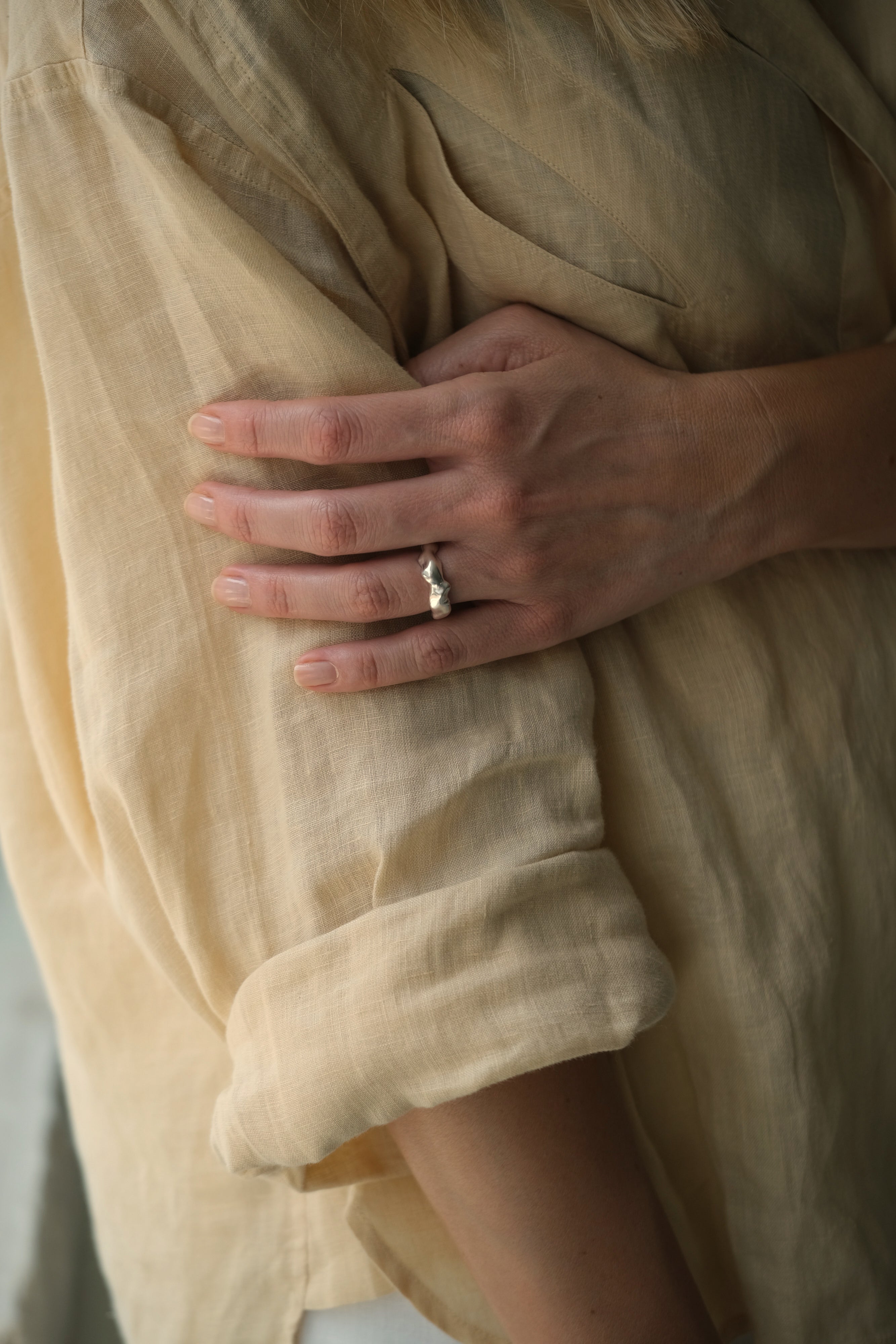 Hand wearing DROP 03 ring five, showcasing unique design in sustainable 925 recycled silver, handmade in Basel, Switzerland.