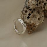 Handmade sustainable silver ring resting on natural texture, unique jewelry from Basel, Switzerland.