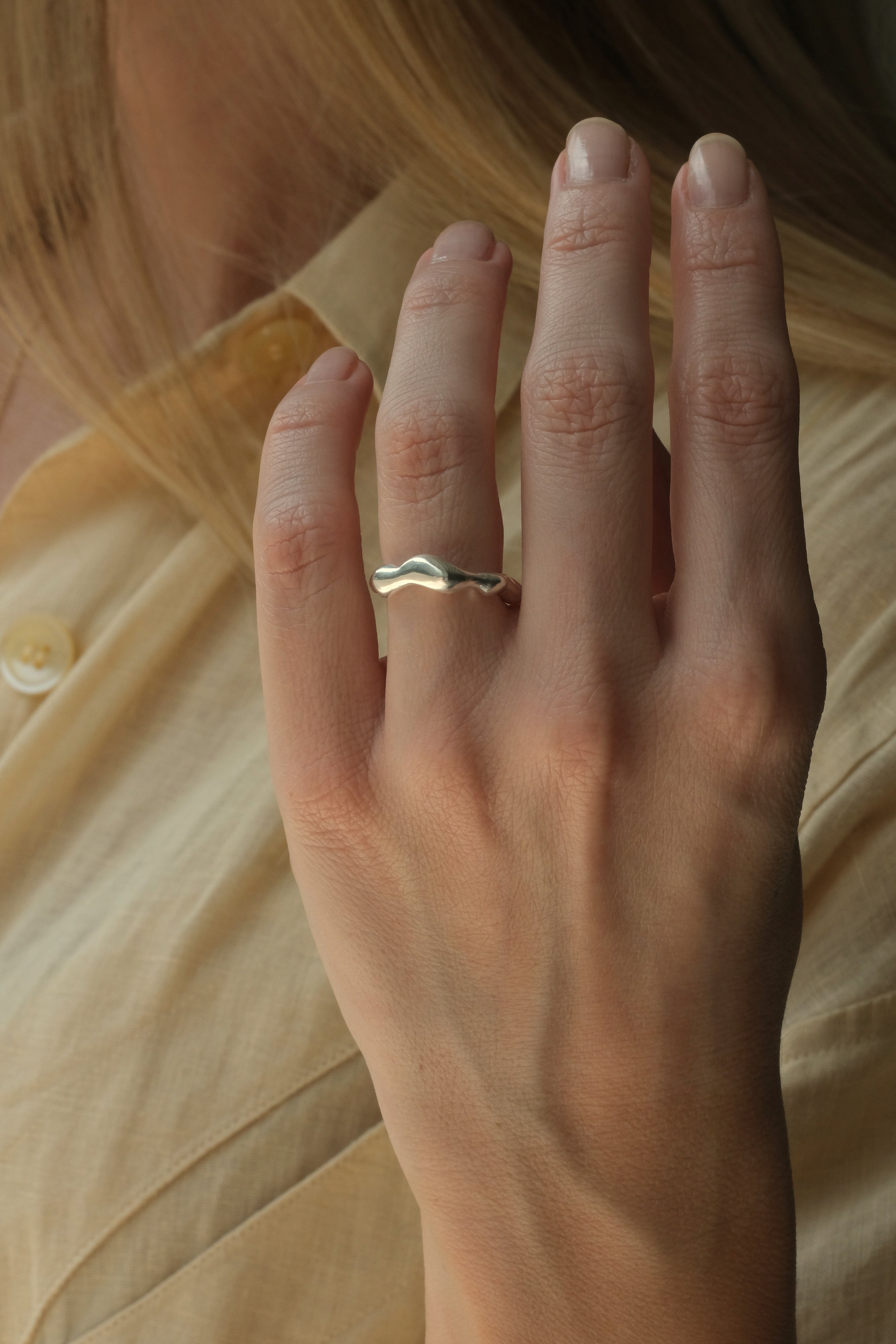 Hand wearing DROP 03 ring in 925 recycled silver, handcrafted in Basel, Switzerland, showcasing unique design.