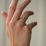 Hand wearing DROP 03 ring in recycled yellow gold, showcasing ethical and sustainable handmade jewelry from Basel Switzerland.