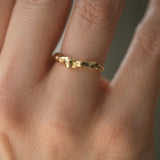 Handmade DROP 03 ring in recycled yellow gold on a finger, showcasing unique ethical and sustainable jewelry from Basel.