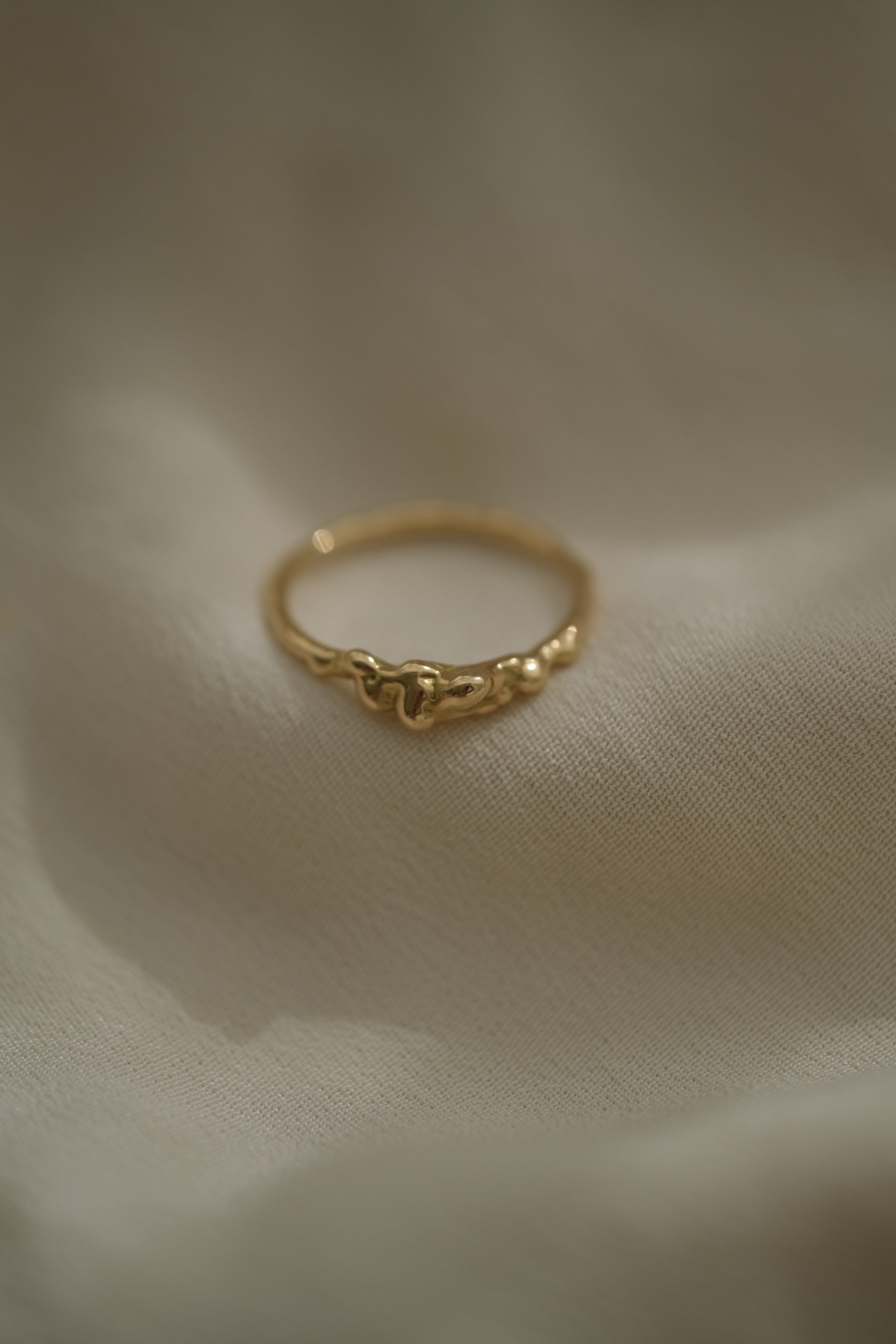 Handmade 18k recycled yellow gold ring, unique and ethical jewelry from Basel, Switzerland on soft fabric.
