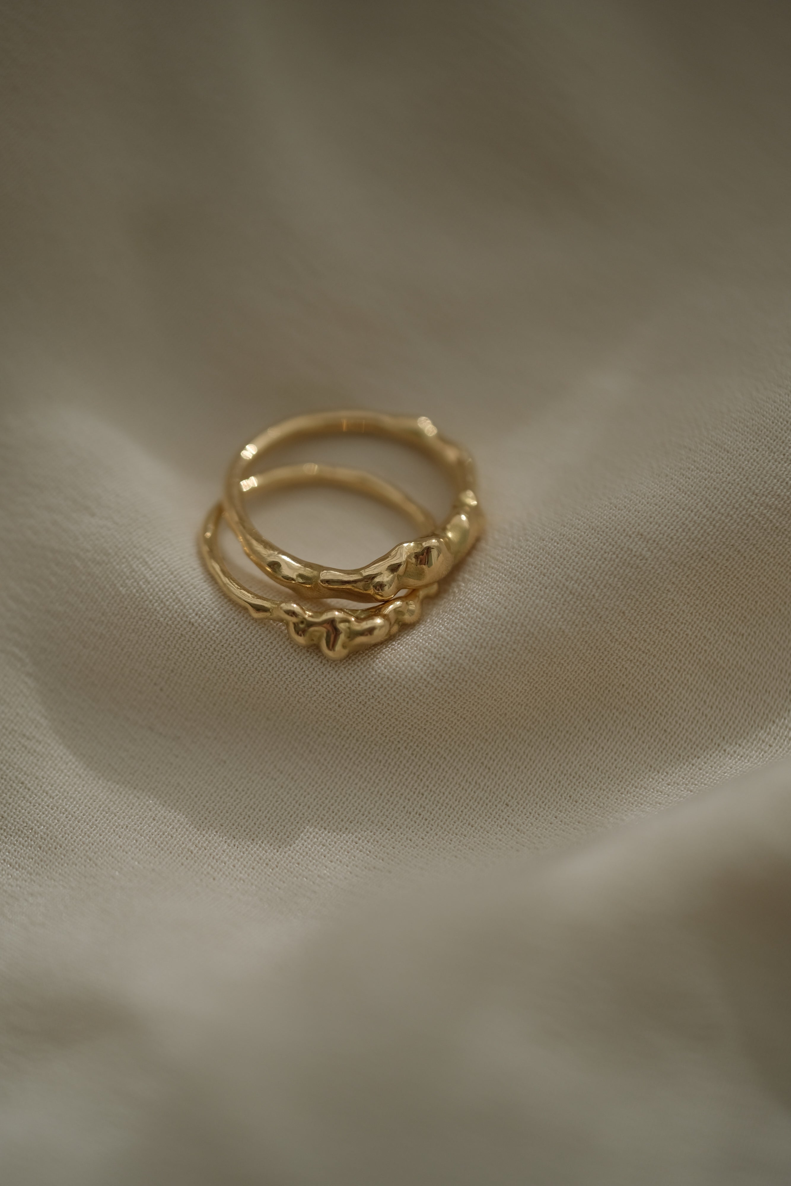 DROP 03 two interlinked rings in recycled yellow gold, showcasing ethical and sustainable jewelry handmade in Basel, Switzerland.