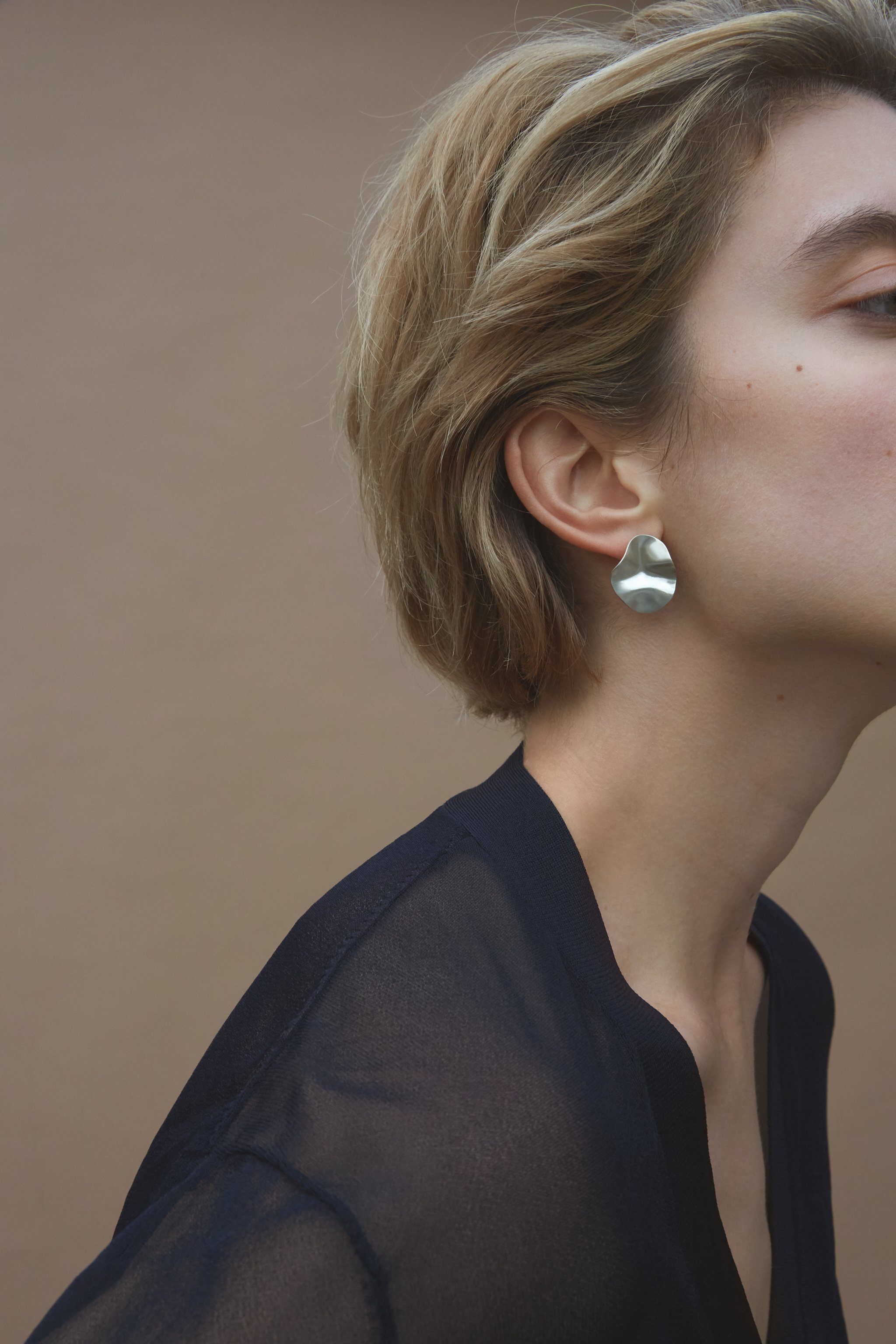Handmade AROYO small earrings in recycled silver showcased on a model, highlighting ethical and sustainable jewelry.