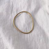 Handmade LOON bangle in 18k gold-plated recycled silver on white fabric, a piece of ethical and sustainable jewelry.