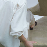 Woman wearing a LOON bangle, showcasing ethical and sustainable handmade jewelry in a minimalist setting.