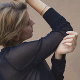 Model showcasing the LOON bangle, a handmade ethical jewelry piece in 18k gold-plated recycled silver.