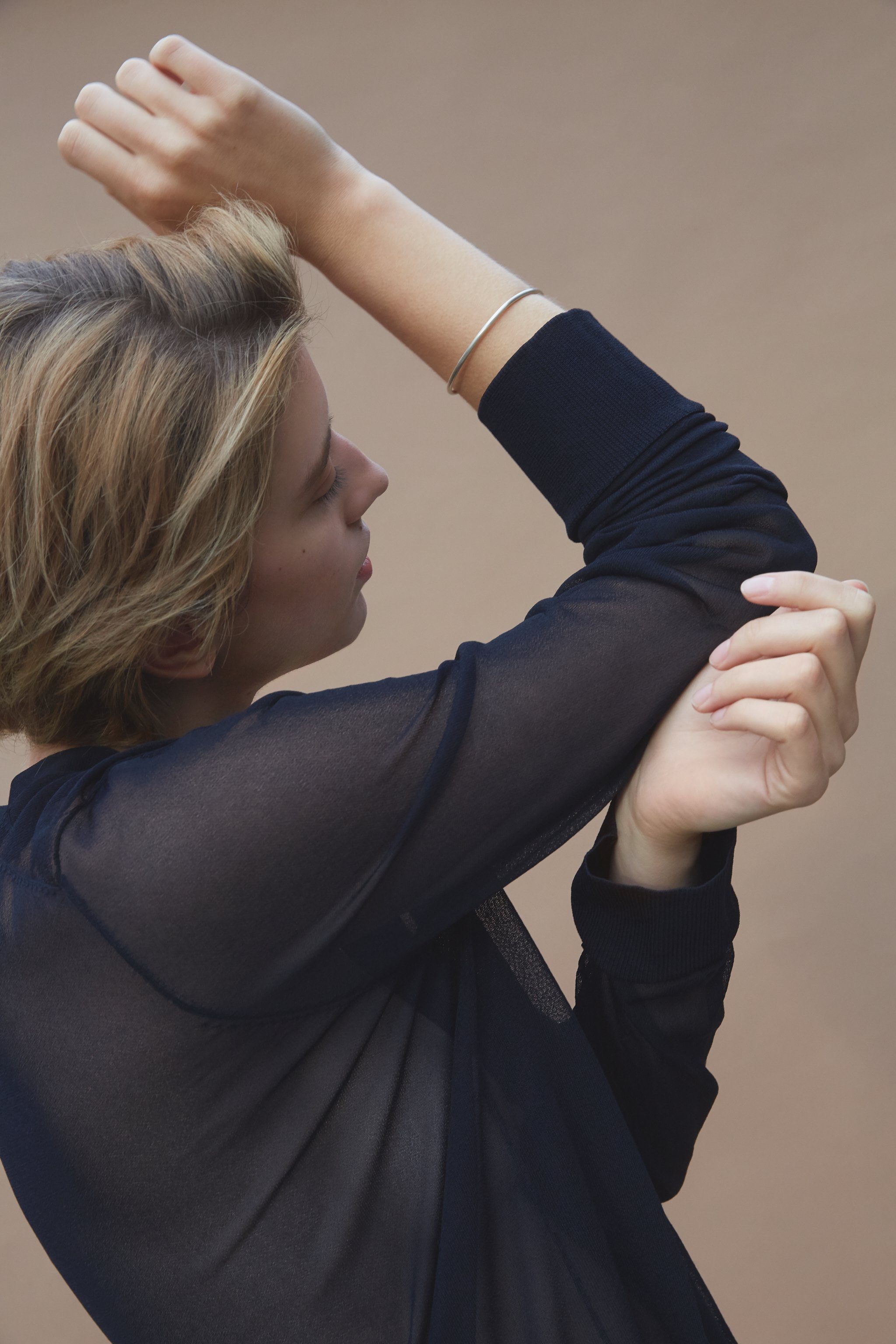 Model showcasing the LOON bangle, a handmade ethical jewelry piece in 18k gold-plated recycled silver.