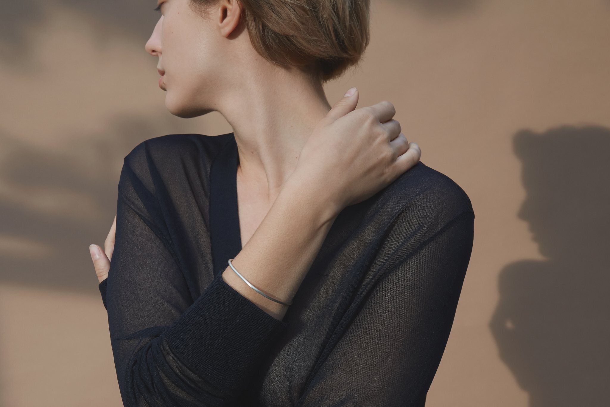 Model showcasing the LOON bangle, an ethical and sustainable jewelry piece, handmade from recycled silver.