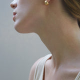 Model showcasing ONOA handmade earrings made of recycled silver and gold, highlighting ethical and sustainable jewelry.