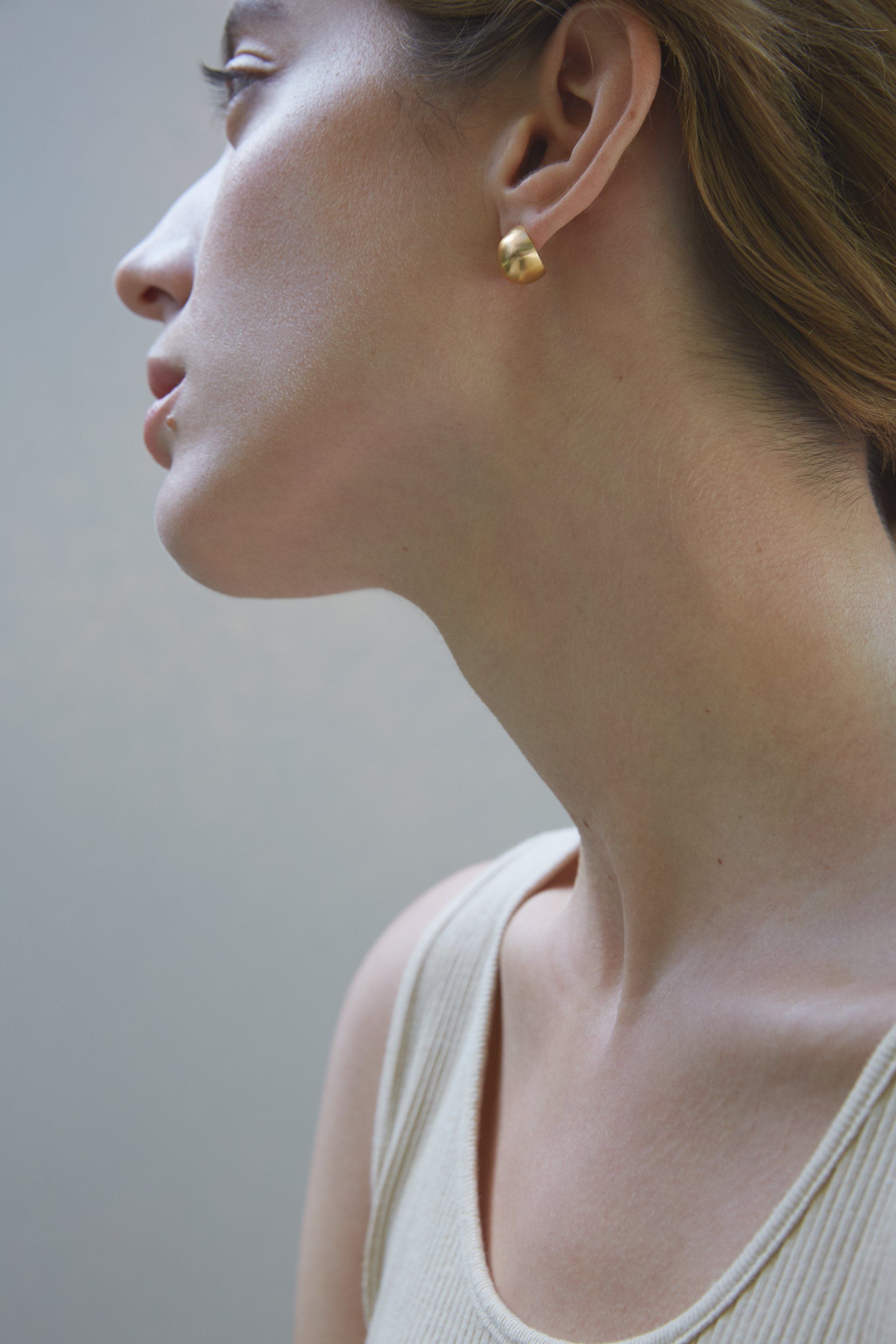 Model showcasing ONOA handmade earrings made of recycled silver and gold, highlighting ethical and sustainable jewelry.